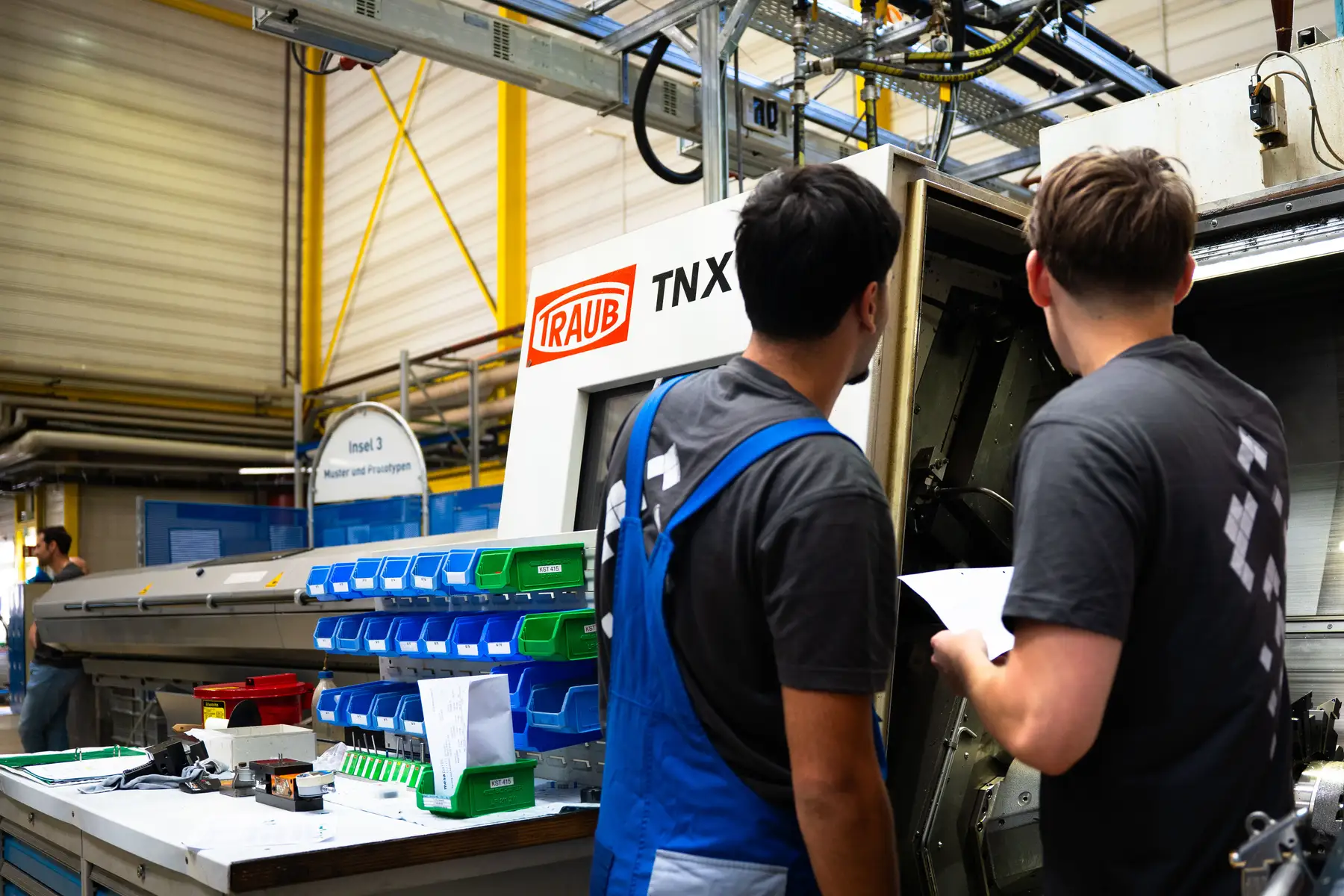 Interns working on a machine in production